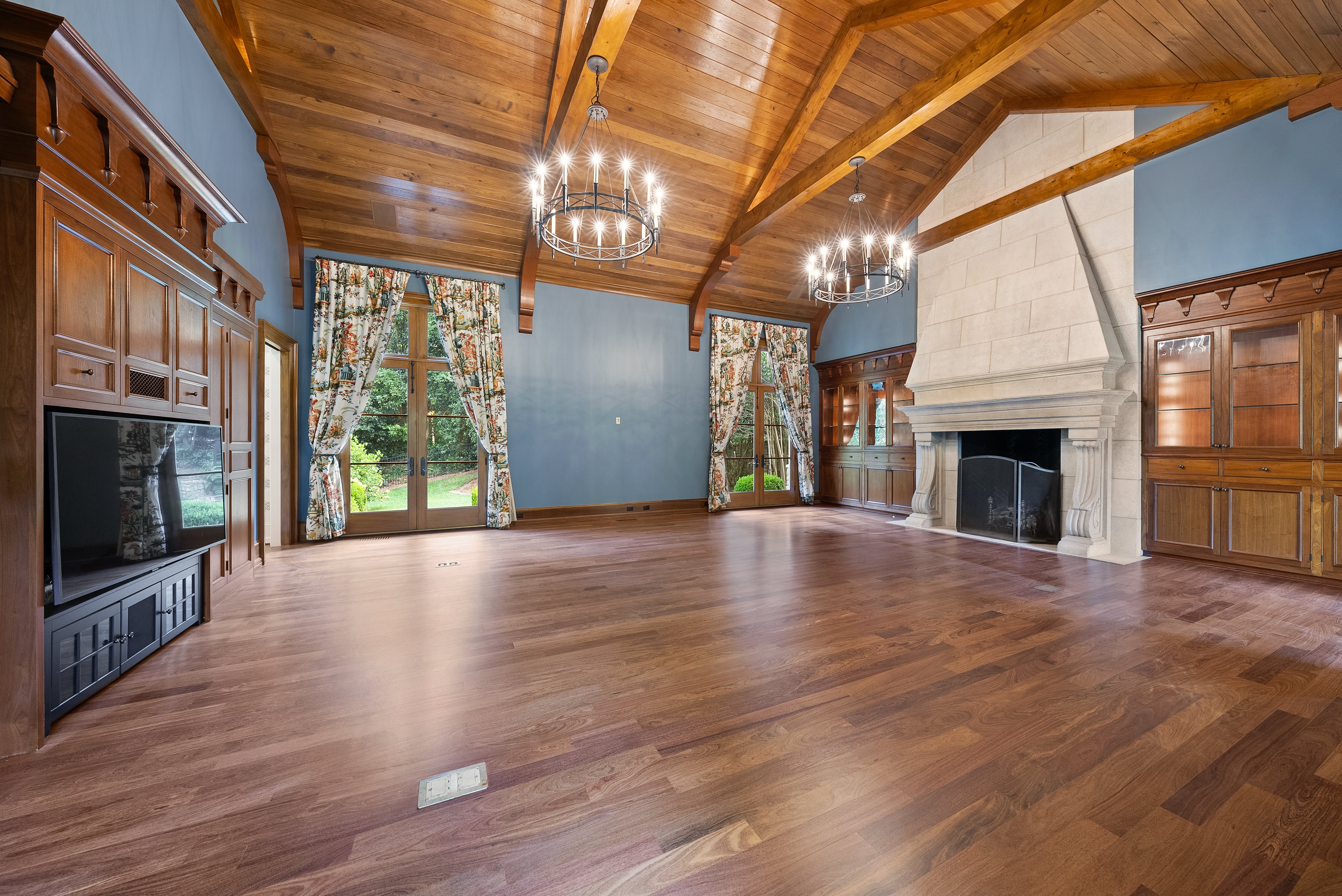 Alternate view of grand blue room, showing television and fireplace