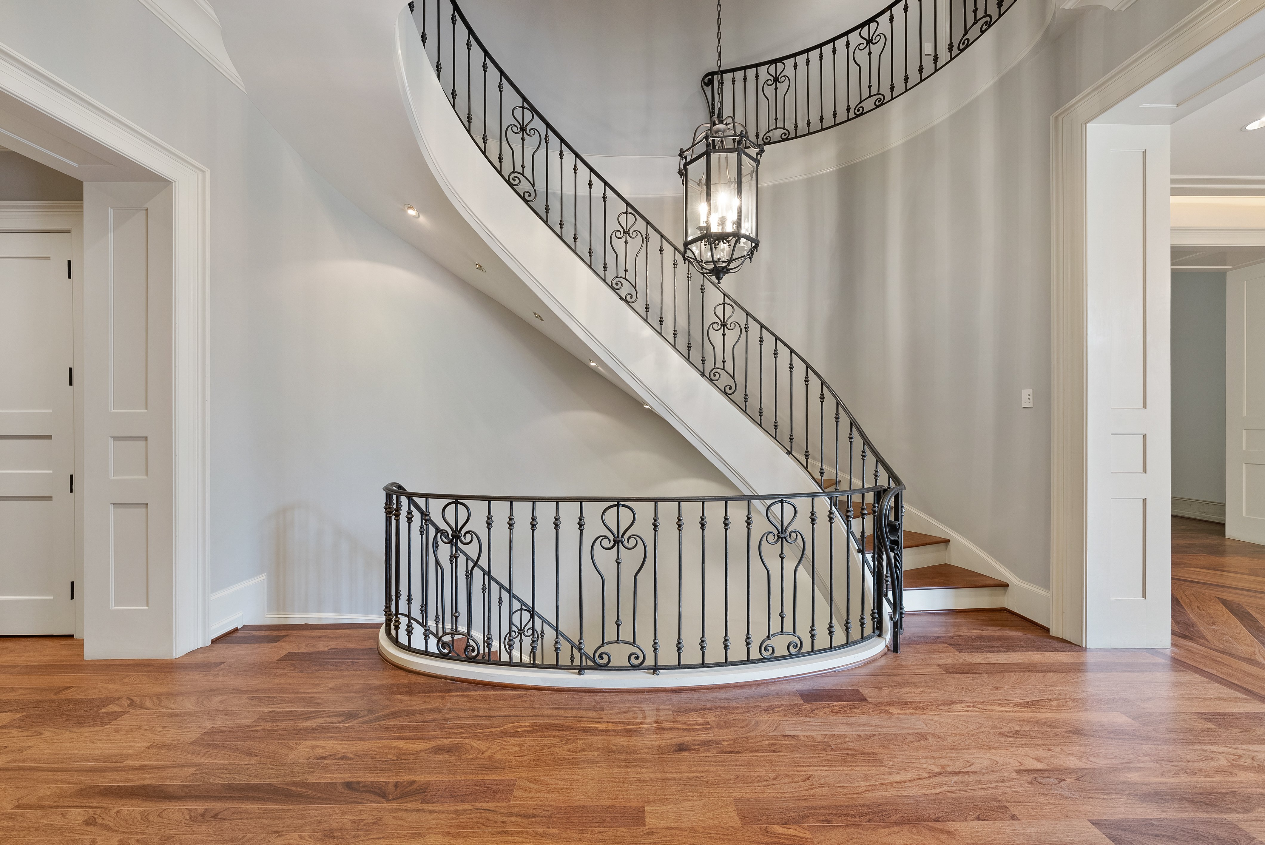 Metal spiral staircase leading to a landing and going upstairs.