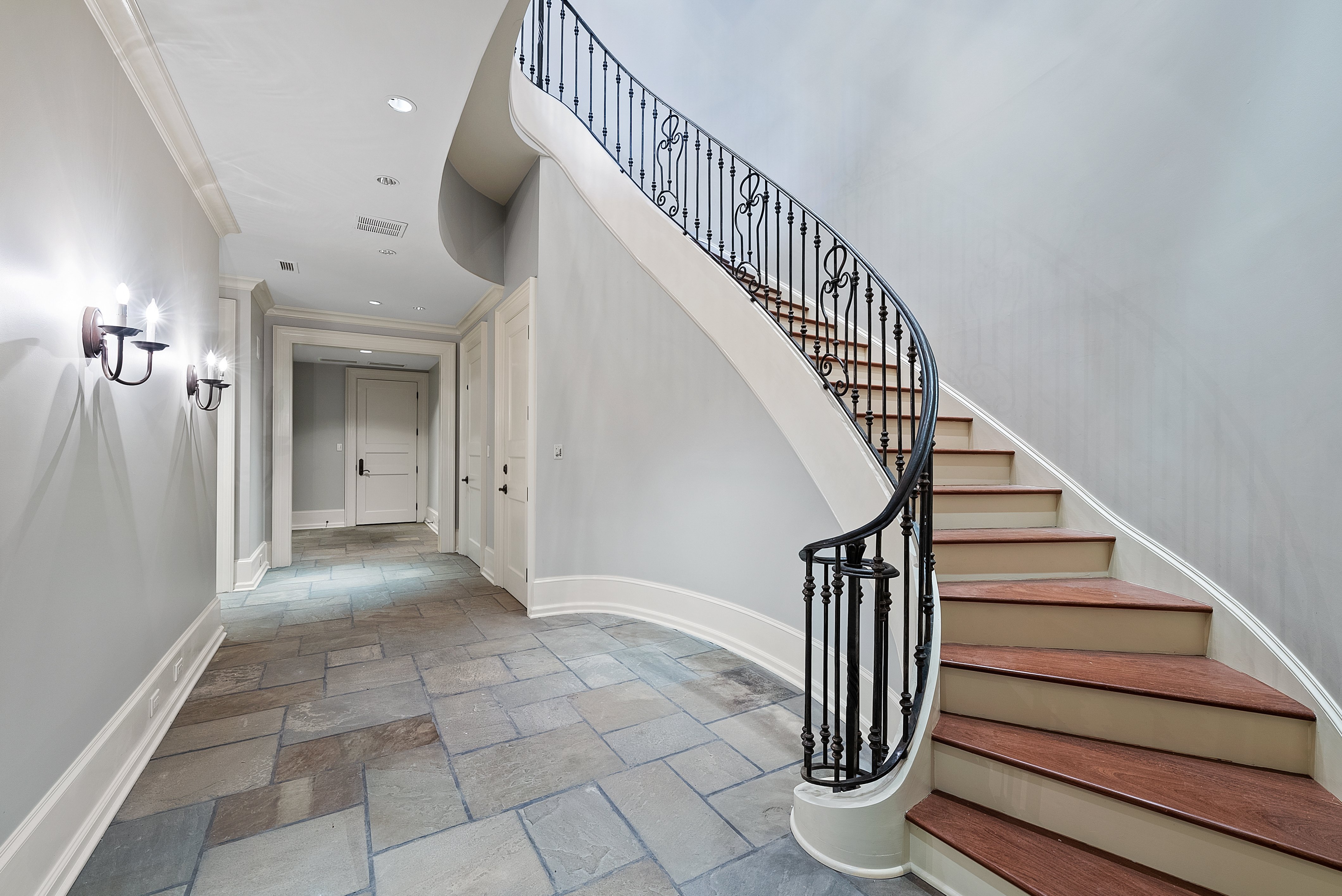 Stone flooring and a spiral staircase leading upstairs.